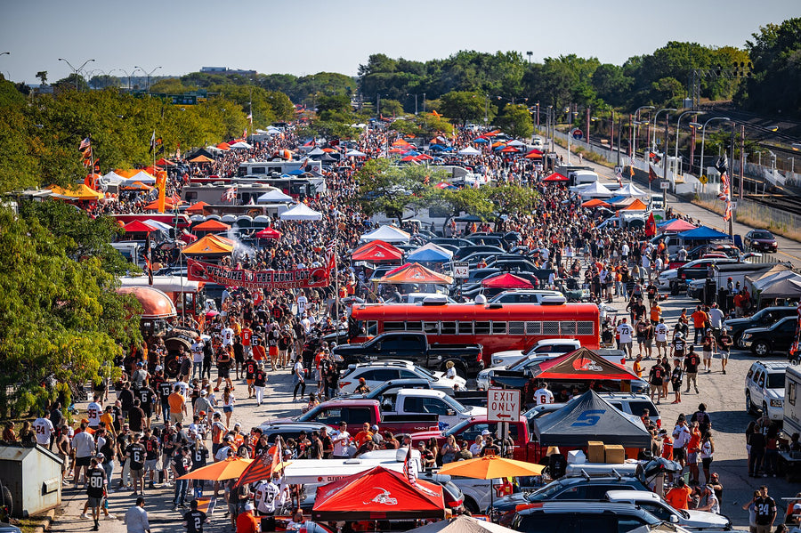 Große amerikanische Tailgate-Party auf einem Parkplatz vor einem NFL-Spiel: Zelte, Pavillons, Busse und Fans