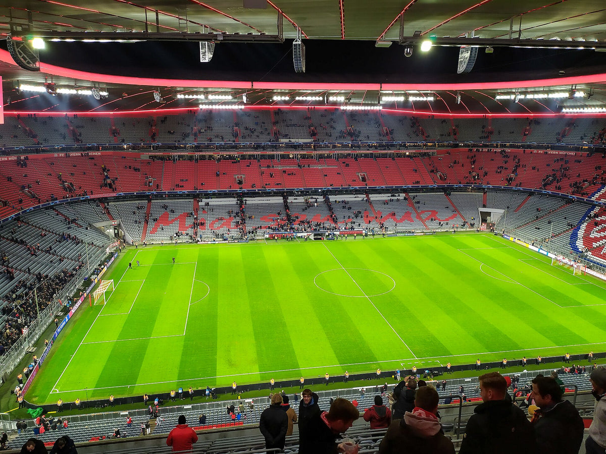 Blick aus dem Oberrang der Osttribüne der Allianz Arena auf die Gegentribüne, das ganze Spielfeld ist sichtbar
